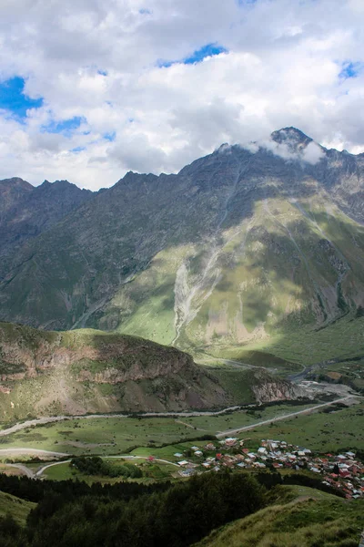 Ana Kafkas (havza) sırtı. Georgia, Kazbegi Köyü (Stepantsminda). Mount Kazbek. Dağlar yaz Gürcü askeri yol. Güzel gökyüzü. Yeşil, yüksek dağlar. Tatil, zam. Gergeti