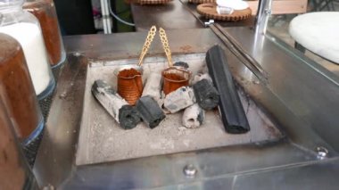 Türk kimliği belirsiz adam sıcak kum ve kömür tarafından demlenmiş kahve.