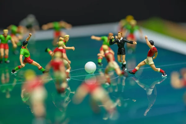 Side view of miniature toys figurines football (soccer) players