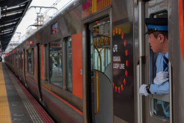 Osaka, Japonya-12 Kasım 2018: Tanımlanamayan tren sürücüsü Osaka, Japonya'daki Shin-Imamiya istasyonunda yolcu arıyor.