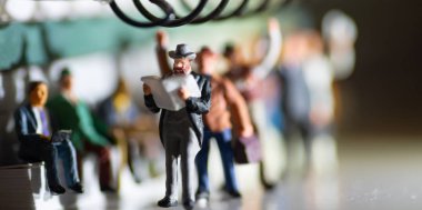 Smokin li bir adamın minyatür oyuncak gazete okumak ve insanlar akşam sarımsı yan aydınlatma ile bir toplu taşıma konsepti üzerinde işten seyahat - bir tren veya otobüs seyahat.