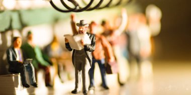 Smokin li bir adamın minyatür oyuncak gazete okumak ve insanlar akşam sarımsı yan aydınlatma ile bir toplu taşıma konsepti üzerinde işten seyahat - bir tren veya otobüs seyahat.