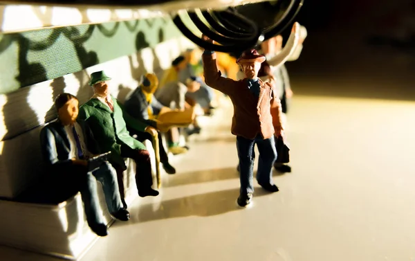 Akşam sarımsı yan aydınlatma ile bir toplu taşıma konsepti üzerinde işten seyahat insanların Minyatür oyuncak - bir tren veya otobüs seyahat.