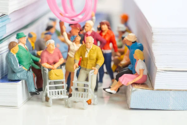 Miniature toy of couple of senior citizen on a public transport concept - travel on a train or bus.