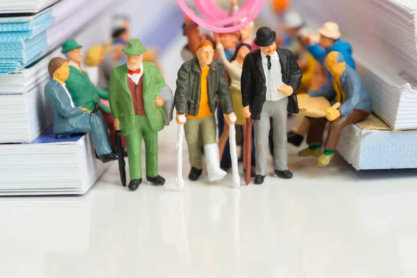 Dolu bir toplu taşıma konseptinde engelli adam ve iki yaşlı adamın minyatür oyuncakları.
