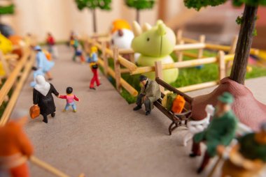 Hayvanat bahçesinde insanların kendi kendine inşa minyatür oyuncaklar kavramı - bir bankta evsiz adam, okul çocukları, banklarda oturan yaşlı insanlar, temizlikçiler hayvanat bahçesi temizlik.