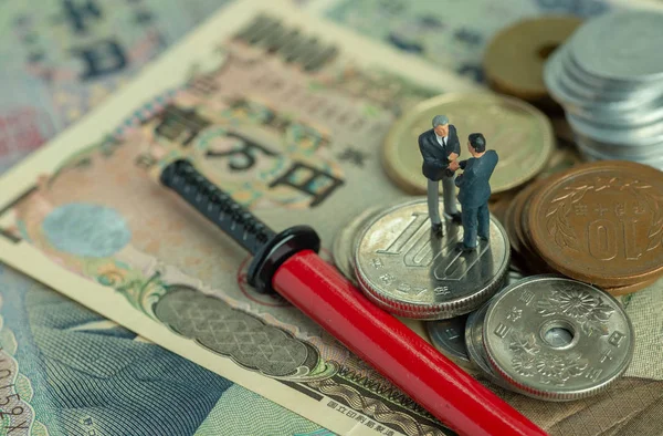 Yen japonés en billetes y monedas y una katana en miniatura en sc rojo —  Fotos de Stock