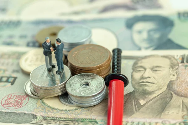 Yen Giapponese in banconote e monete e una katana in miniatura in rosso sc — Foto Stock