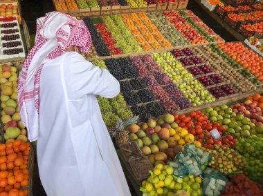 Kimliği belirsiz Arap adam taze meyve satıyor.