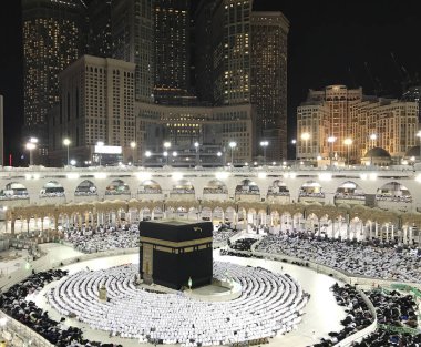 Akşam namazı sırasında Kabe'ye bakan secde (sujud) pozisyonunda kimliği belirsiz Müslüman hacıların kuş bakışı görünümü.