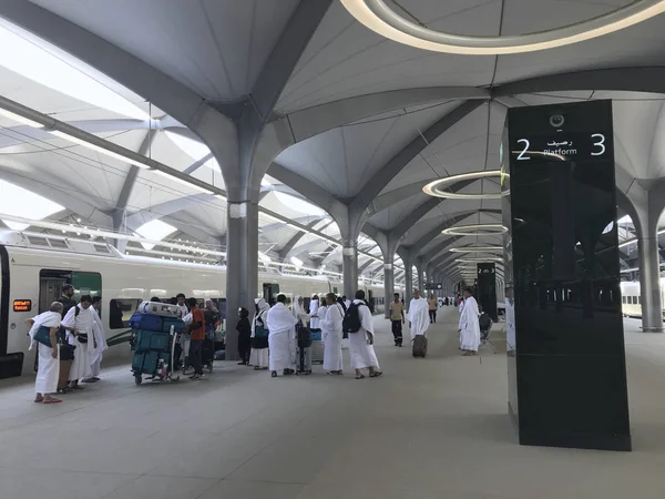 Un grupo de hombres vestidos de ihram blanco desembarcan de los vagones de tren en la estación de HSR Mecca en La Meca, Arabia Saudita . — Foto de Stock