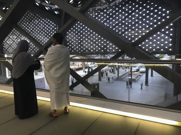 A Muslim couple overlooks  bullet trains on tracks at HSR Madinah station in Medina, Saudi Arabia. — Stock Photo, Image
