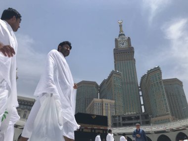MECCA, SAUDI ARABIA-CIRCA MAY 2019 :Abraj Al Bait (Royal Clock Tower Makkah) in Makkah, Saudi Arabia while Muslim pilgrims circumambulate (tawaf) the Kaaba. clipart