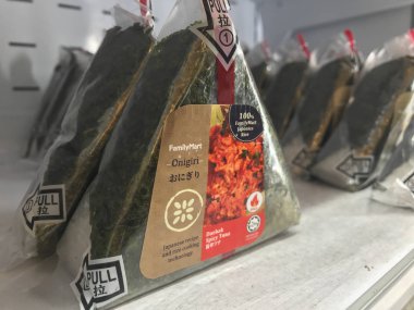Kuala Lumpur, Malezya - 9 Temmuz 2019 : Family Mart mağazasında satılan helal onigiri sıraları. Onigiri üçgen şeklinde pirinç topu oluşur, çeşitli tatlar ile doldurulmuş ve yosun sarılmış.