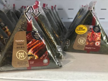 Kuala Lumpur, Malezya - 9 Temmuz 2019 : Family Mart mağazasında satılan helal onigiri sıraları. Onigiri üçgen şeklinde pirinç topu oluşur, çeşitli tatlar ile doldurulmuş ve yosun sarılmış.