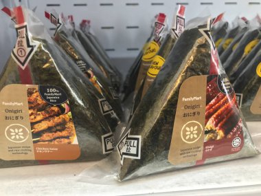 Kuala Lumpur, Malezya - 9 Temmuz 2019 : Family Mart mağazasında satılan helal onigiri sıraları. Onigiri üçgen şeklinde pirinç topu oluşur, çeşitli tatlar ile doldurulmuş ve yosun sarılmış.
