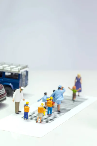 Miniature toys school kids walk on cross road bar code - school children road safety concept - top view