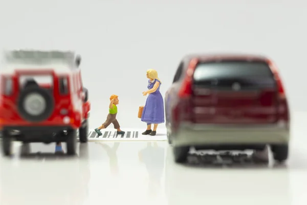 Miniature toys school kids walk on cross road bar code - school children road safety concept -  side view