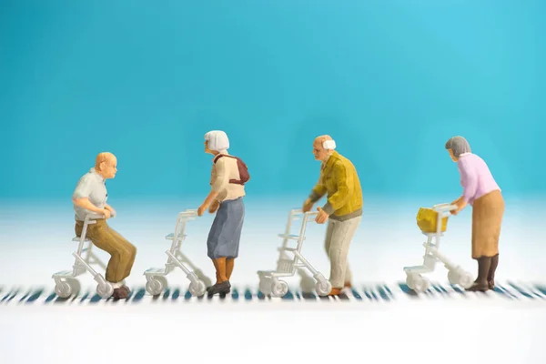 Miniature toys a group of old people with wheel chair crossing a — Stock Photo, Image