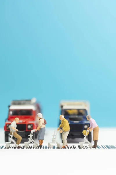 Juguetes en miniatura un grupo de ancianos con silla de ruedas cruzando un — Foto de Stock
