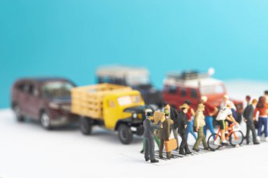 Gazete okuyan bir adamın minyatür oyuncakları, bir sokaktan geçerken çevresini habersiz, okuma alışkanlığı kavramı.