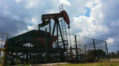 Yağ pompası silueti çalışıyor. Seria 'da petrol endüstrisi, Brunei Darussalam bulutlu mavi gökyüzü ile güneşli bir günde.