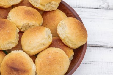 Ev yapımı ekmek ya da topuz ahşap arka plan üzerinde bir kil plaka. Homemade pişirme