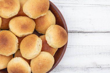 Ev yapımı ekmek ya da topuz ahşap arka plan üzerinde bir kil plaka. Homemade pişirme