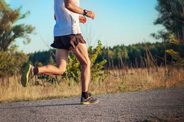 Running man of athletic build in shorts, T-shirt and sneakers