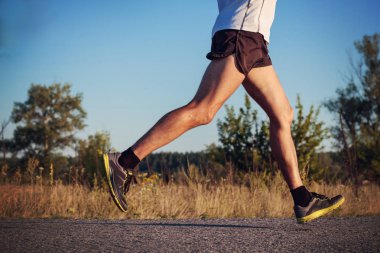 Adam atletik yapılı, şort, tişört ve spor ayakkabı çalışan