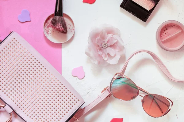 Ladies Fashion Accessories. Pink Clutch, sunglasses, earrings, makeup brush and face powder. Pastel colors Trend