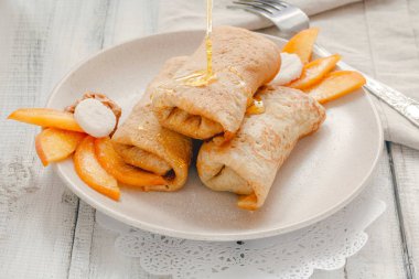 Ev yapımı krep veya şeftali, bal ve rustik ahşap arka plan üzerinde plaka üzerinde fıstık ezmesi ile Rus blini. Doldurulmuş Krep yerken üzerine seramik