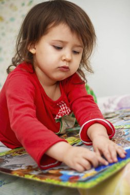 küçük kız Pijama içinde Kafkas görünümü bir odada bulmacalar toplar