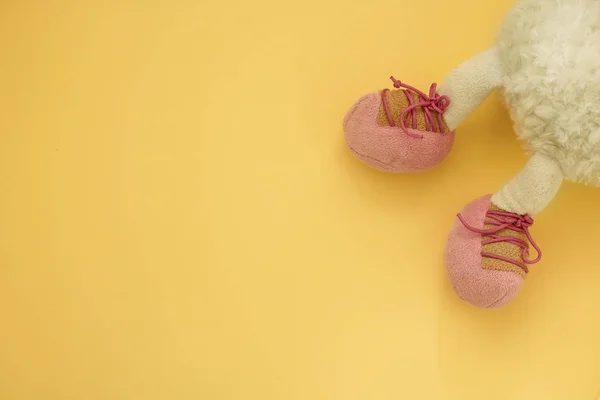 Piepende voeten van zachte kinderspeelgoed op een gele achtergrond — Stockfoto