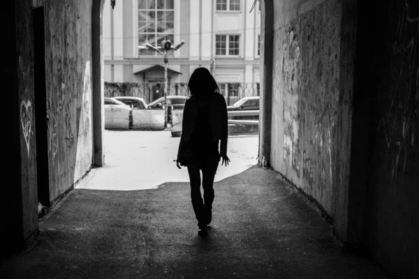 Foto en blanco y negro, silueta de una niña en el arco arquitectónico del túnel —  Fotos de Stock