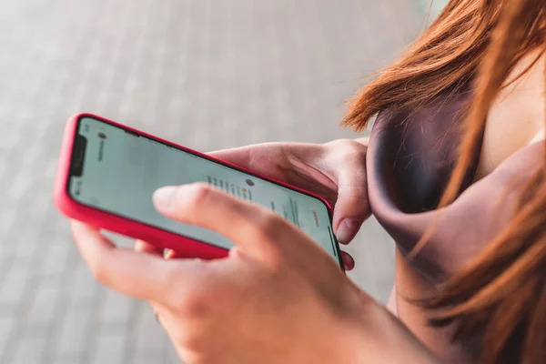 Adolescente heureuse utilisant un téléphone intelligent marchant une journée ensoleillée dans la rue — Photo