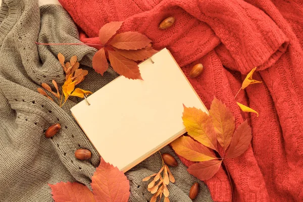 Flat lay composition with book, autumn leaves and warm clothes, mock up