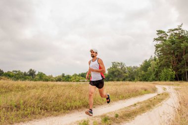 Doğada, gün, açık havada bir spor üniforması sakallı açık havada çalışan adam