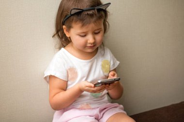 eğitim, okul, teknoloji ve internet konsepti - evde akıllı telefonu olan küçük kız