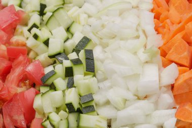 Bir güveç veya diğer vegan yemeği için dilimlenmiş sebzeler (domates, kabak, soğan, havuç,)