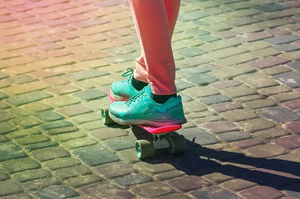 Młody deskorolkarz nogi w różowe rajstopy i niebieskie trampki skatebo — Zdjęcie stockowe