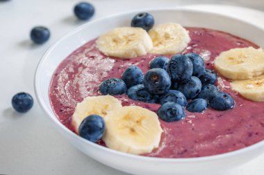 Beyaz arka planda yabanmersinli ve muzlu vejetaryen meyve püresi. Yakın plan, gündüz.