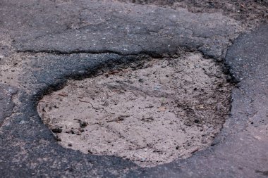 Asfalt karayolu üzerinde taşlarla büyük çukur