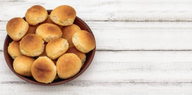 Ahşap kaplamalı kil tabakta ev yapımı ekmek ya da çörek. Ev yapımı pişirme. Kopyalama alanı