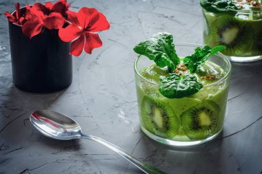 Gri arka planda kivi ve ıspanaklı yeşil taze meyve püresi. Detoks konsepti. Vejetaryen