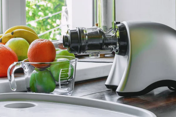 Gray horizontal juicer on table with fruit. Concept - healthy lifestyle, detox, diet, vitamins — 스톡 사진