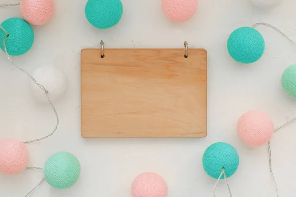 Attrappe aus Holz und um eine bunte Girlande aus großen Kugeln in Pastellfarbe, Tag, Flatlay, Copyspase — Stockfoto