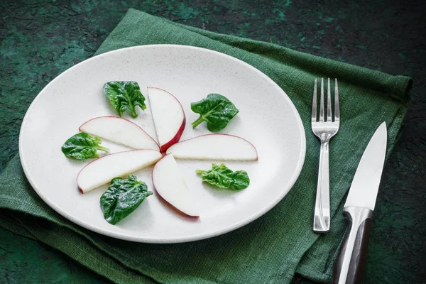 一组红色苹果片放在盘子里的顶部视图，盘子里有绿色背景的餐具。 饮食概念 — 图库照片