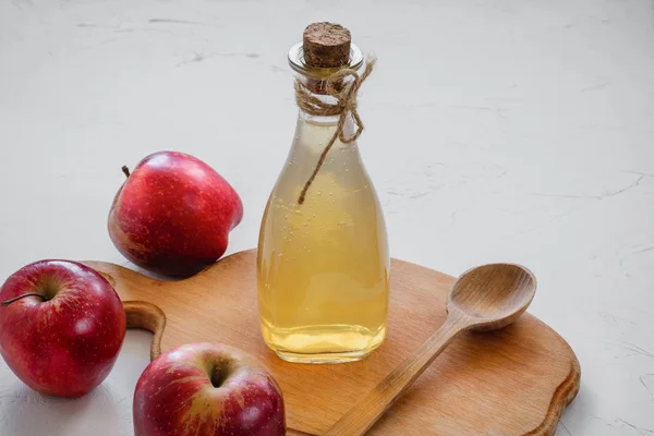 Vinagre de manzana. Botella de vinagre orgánico de manzana sobre fondo blanco con manzanas rojas crudas enteras. Alimento ecológico saludable . — Foto de Stock