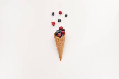 Waffle külahında bir buket yaban mersini ve ahududu. Beyaz arka planda minimal stil. Lezzetli yaz tatlıları ve iyi beslenme konsepti.